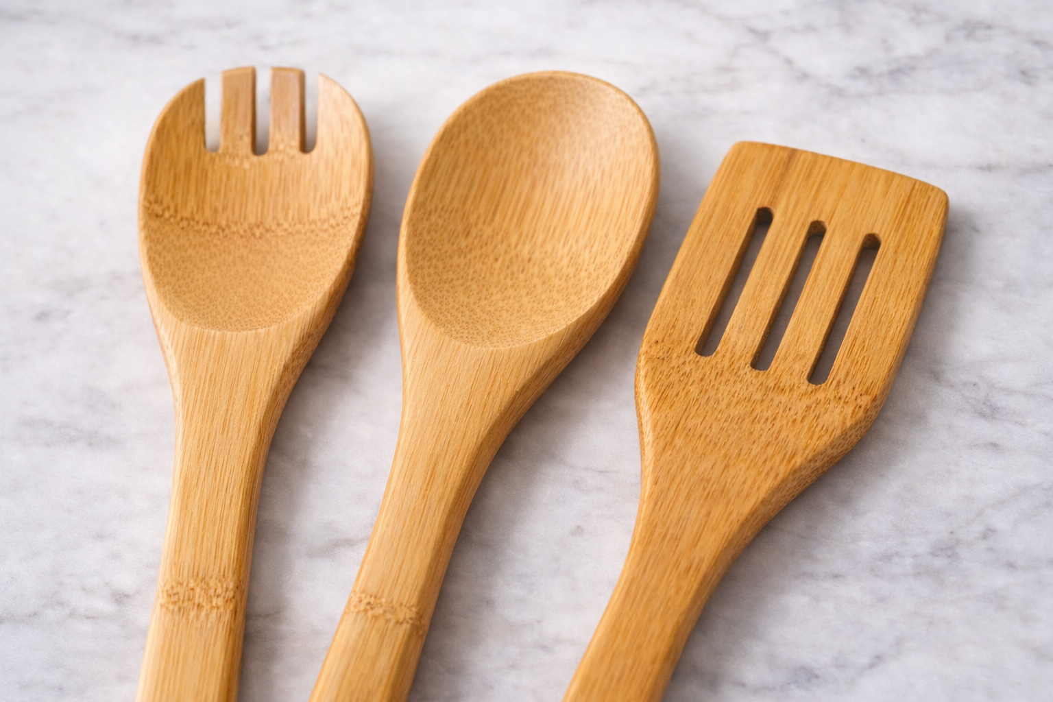 Three wooden utensils on a marble surface