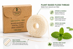 Biodegradable dental floss with packaging and mint leaves on a white background