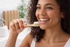Woman holding a wooden toothbrush with toothpaste in a bathroom setting