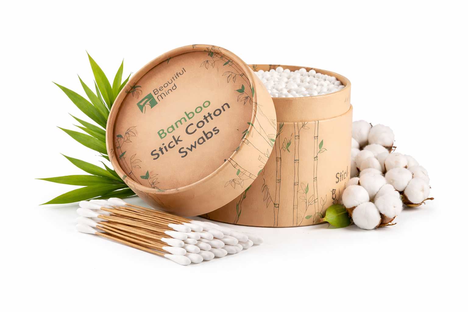 Bamboo stick cotton swabs in a cardboard container with cotton buds and leaves on a white background