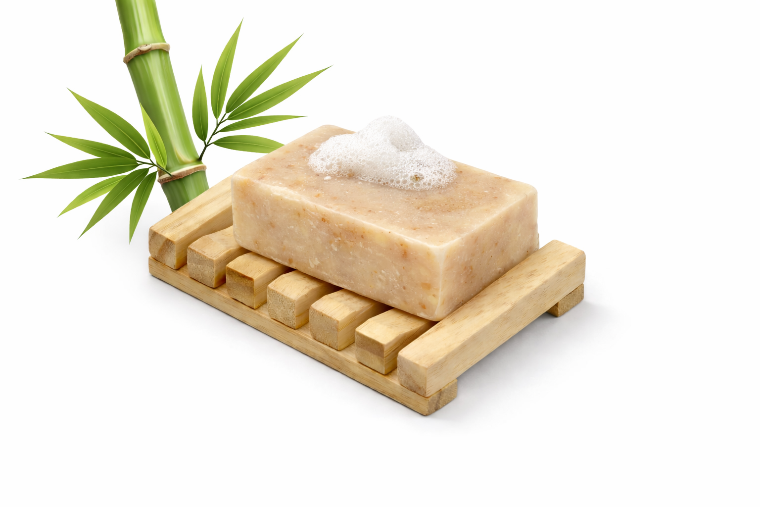 Bar of soap on a wooden soap dish with bamboo leaves on a white background