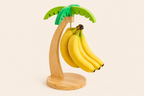 Wooden banana holder shaped like a palm tree with bananas on a beige background