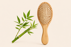 Wooden hairbrush with a bamboo branch on a beige background