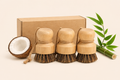 Three wooden brushes with coconut and bamboo on a beige background