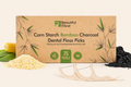 Box of Beautiful Mind corn starch bamboo charcoal dental floss picks with floss and ingredients on a beige background