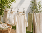 Children's clothing hanging on a clothesline with a basket of laundry.